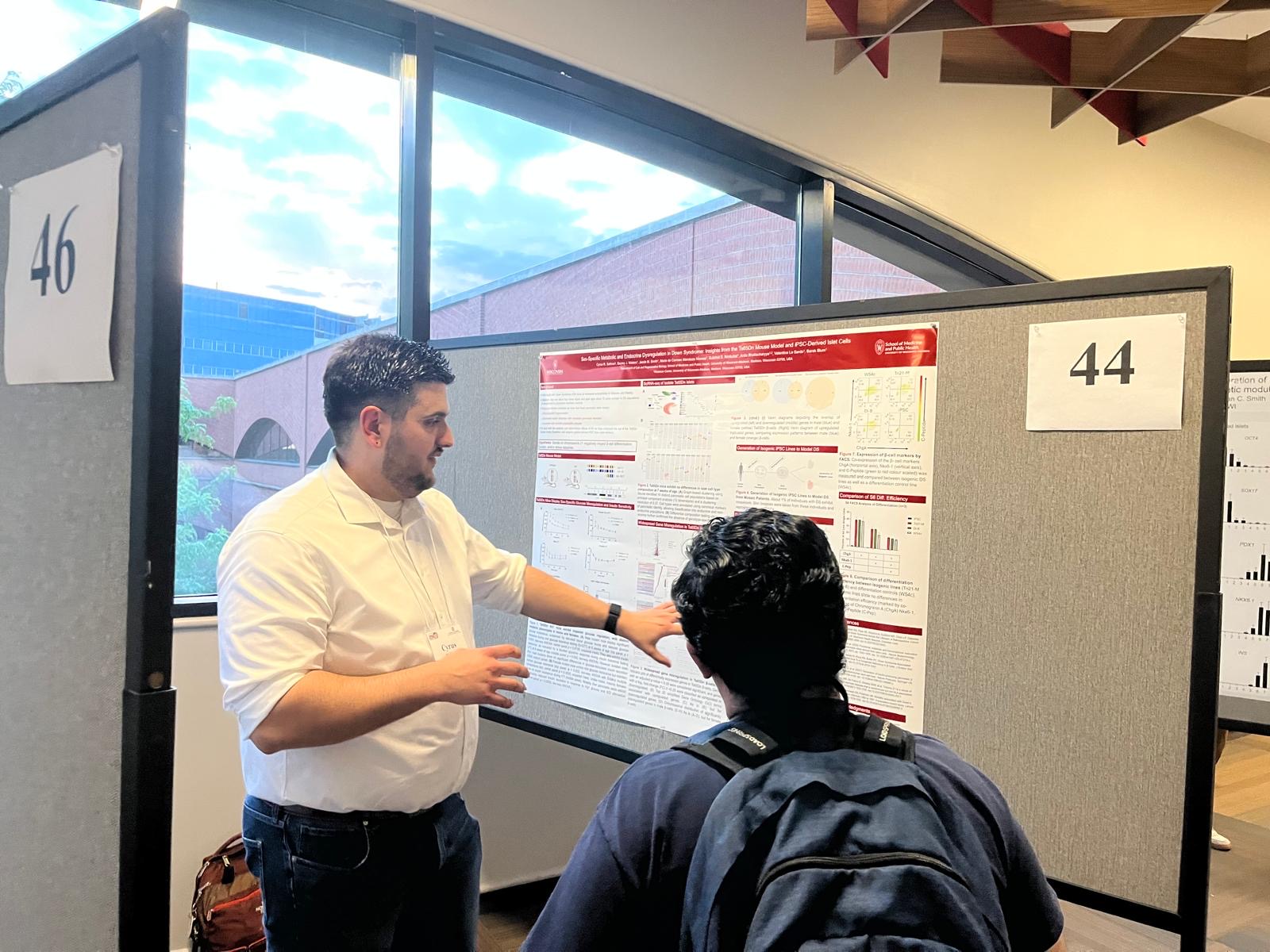 Cyrus orating to an individual about his poster at Midwest Islet Club in May, 2025