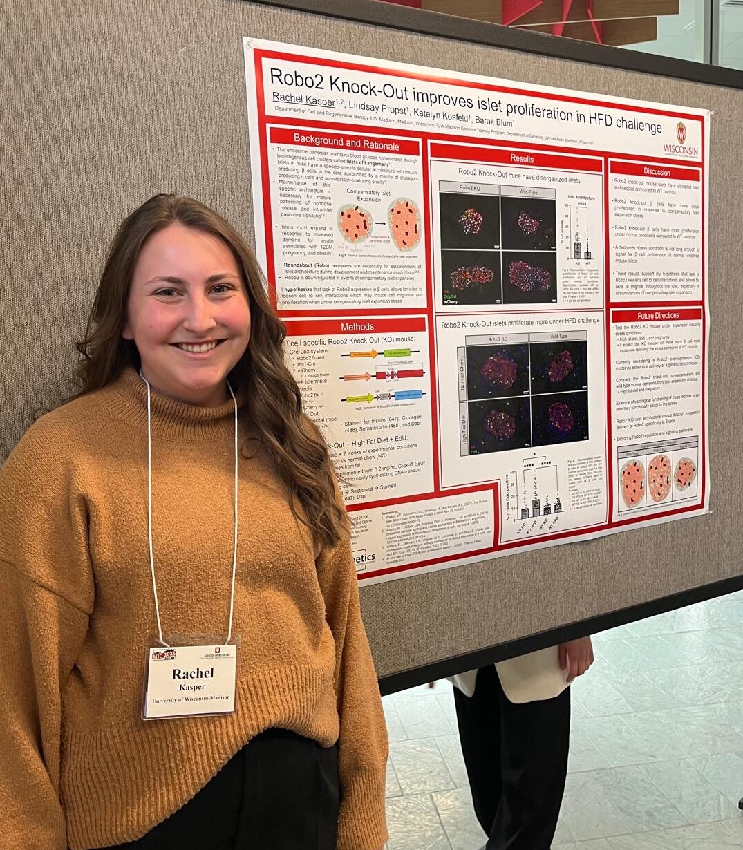 Rachel standing next to her poster at Midwest Islet Club in May, 2025