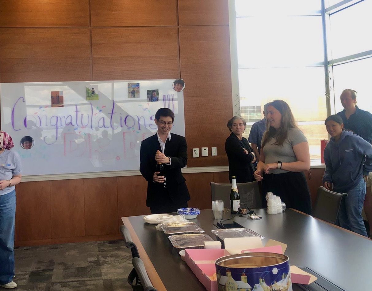 Dex opening a bottle of champagne after his thesis defense on June 26th, 2025.
