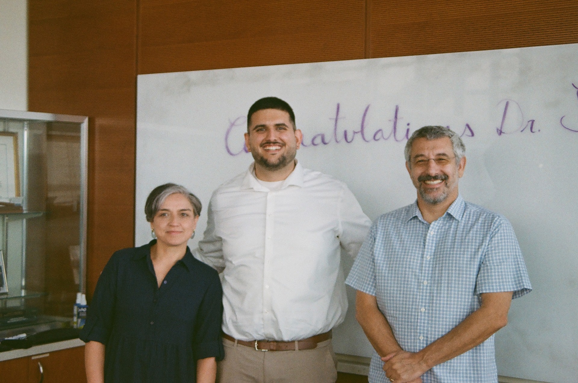 From left to right, Valentina Lo Sardo, Cyrus Sentha, and Barak Blum, posing for a photo the day of Cyrus's PhD defense in July, 2026.